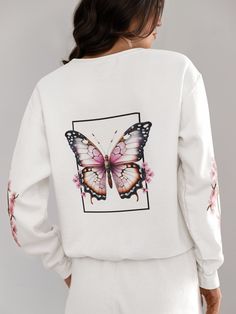 Introducing the Butterfly Cherry Blossom Crewneck Sweatshirt, a delightful fusion of nature-inspired beauty and cozy comfort. This enchanting garment seamlessly blends the delicate elegance of cherry blossoms with the whimsical grace of butterflies, creating a unique and eye-catching design. Crafted from premium quality, soft cotton-blend fabric, this crewneck sweatshirt is not only a fashion statement but also a plush haven for warmth and comfort. The cherry blossom pattern adorning the sleeves and hem of the sweatshirt adds a touch of ethereal charm, capturing the fleeting beauty of spring in every detail. The butterfly motifs, delicately embroidered or printed on the chest and back, lend an air of sophistication to the overall design. The vibrant colors of the butterflies harmonize with Casual Printed Sweater For Spring, Spring Graphic Print Relaxed Sweater, Printed Crew Neck Sweater For Spring, White Floral Print Sweatshirt For Fall, White Long Sleeve Top With Butterfly Print, White Long Sleeve Sweatshirt For Spring, Graphic Print Sweatshirt For Spring Loungewear, Long Sleeve Cotton Tops With Butterfly Print, Long Sleeve Tops With Butterfly Print For Fall