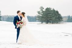 a bride and groom standing in the snow