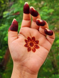 a woman's hand with red flowers painted on it