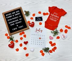 a baby's first valentine's day outfit and other items laid out on a table