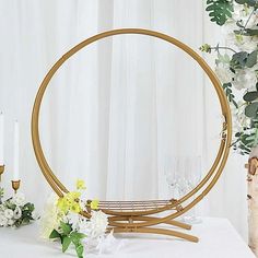 a round mirror sitting on top of a white table next to flowers and candle holders