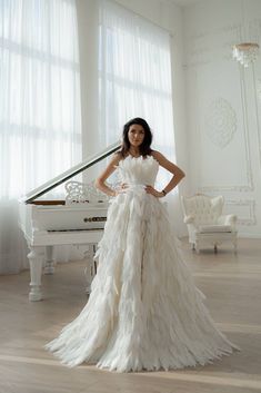 a woman standing in front of a white piano