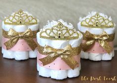 three baby shoes with bows and tiaras on them are sitting next to each other