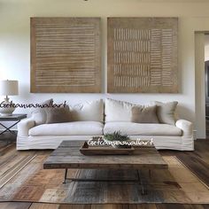 a living room with two paintings on the wall and a coffee table in front of it