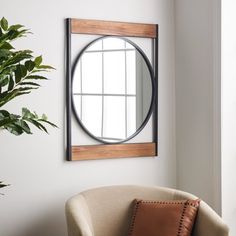 a living room with a chair, mirror and potted plant