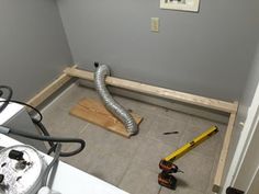 an unfinished room with tools on the floor and a blow dryer in the corner