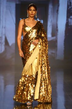 Gold saree with all-over sequin embroidery. Comes with sleeveless blouse and petticoat.
Component: 3
Pattern: Embroidery
Type Of Work: Sequin
Neckline: Sweetheart
Sleeve Type: Sleeveless
Fabric: Foil Georgette
Color: Gold
Other Details: 
Shoulder straps with sequin embroidery
Occasion: Wedding - Aza Fashions Gold Saree, Embroidered Saree, Gold Blouse, Sequin Embroidery, Luxury Sale, Blouse For Women, Pattern Embroidery, Sequins Embroidery, Buy Gold