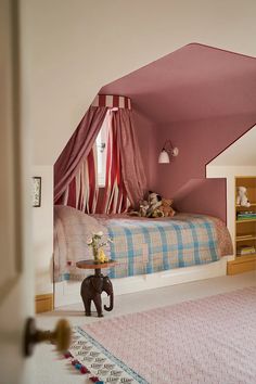 a bedroom with pink walls and an elephant table