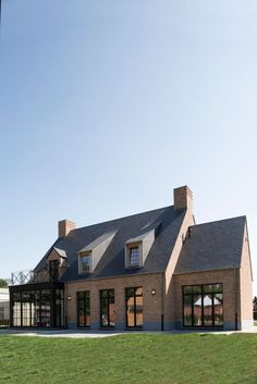 a large brick house sitting on top of a lush green field