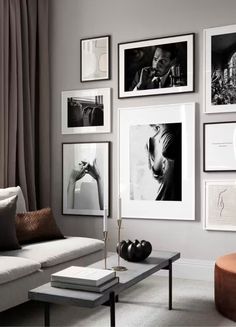 a living room filled with lots of pictures on the wall above a couch and coffee table