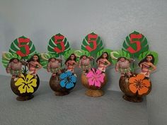 there are five hawaiian themed vases on the shelf in front of each other,