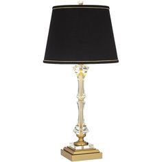 a lamp with a black shade on top of it and gold trimming around the base