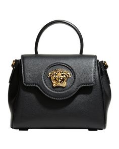 Versace top handle bag in leather. Adorned with a Medusa plaque – the same décor that was discovered on the doors of the brand's first headquarters in Milan Signature tonal Medusa head at front. Rolled top handle, 3" drop Removable, adjustable leather shoulder strap, 18"-19 1/2" drop Chain shoulder strap, 11" drop Slouchy silhouette can be styled on the wrist or across the shoulder Flap top with magnetic snap closure. Interior, slip pocket. Approx. 6.7"H x 7.8"W x 3.9"D... Bottega Veneta Arco, Versace Top, Versace Bag, Medusa Head, Suede Handbags, Womens Designer Handbags, Versace Bags, Gold Handbags, Small Handbag