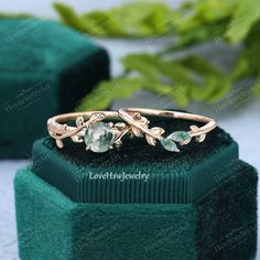 an image of a ring with purple stones in it on top of a green box