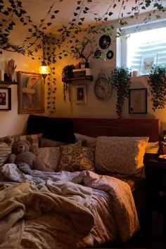 an unmade bed in a bedroom with lots of plants on the wall above it