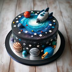 a space themed cake with planets, stars and a rocket ship on it's side