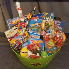 a green basket filled with lots of toys and other items on top of a table