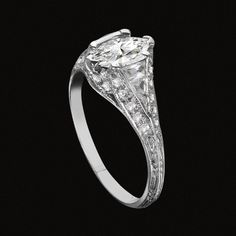 a diamond ring on a black background with the center stone surrounded by small white diamonds