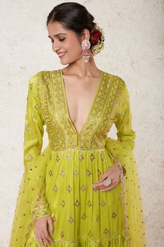 Editor's Note Radiate beauty in this lime green tiered anarkali, adorned with exquisite gota patti motifs and delicate applique work. This stunning ensemble comes complete with a matching churidar and dupatta, adding a touch of grace and elegance to your look. Embrace the allure of traditional craftsmanship and be the center of attention at any event or celebration. Fabric: Tussar silk, net tikki Color: Green Component: Anarkali, churidar and dupatta Occasion: Festive and wedding guest Note: Pro Pista Green Gota Work Dress, Anarkali Style Floor-length Pista Green Palazzo Set, Pista Green Anarkali Kurta With Gota Work, Traditional Green Floor-length Palazzo Set, Festive Green Palazzo Set With Dupatta, Bollywood Style Green Chanderi Palazzo Set, Traditional Green Palazzo Set With Dori Work, Green Floor-length Palazzo Set For Navratri, Bollywood Style Green Palazzo Set For Navratri