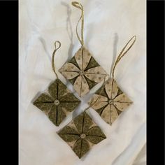 three origami ornaments are hanging on a white sheet