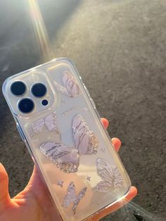 a person holding up a clear case with butterflies on it