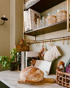 a loaf of bread sitting on top of a wooden cutting board next to a basket