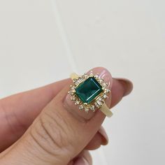 Estate/ vintage 14KT yellow gold lab-created, emerald-cut emerald with surrounding, baguette + round diamonds halo ring. Would make a fantastic emerald engagement ring or just an added ring to your collection! Size 6.25 Can be resized for an additional fee Lab Emerald 1.85~2.00+CTW Emerald-cut emerald measures: 8mm x 5mm Round (14) round natural diamonds; SI clarity; H color, (6) natural, baguette diamonds; VSI clarity; H color Stamped 14K Weight: 3.40 grams Excellent estate condition Rings 2023, Vintage Emerald Engagement Ring, Ballerina Ring, Round Diamond Halo, Deco Rings, Emerald Ring Vintage, Saint Jewelry, Emerald Ring Gold, Baguette Diamonds