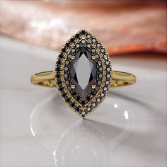 a black and white diamond ring sitting on top of a table