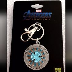 the avengers endgame keychain has a light blue circle with an iron man symbol on it