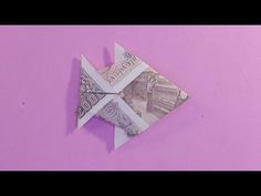 an origami fish made out of money on a pink background with the words,