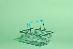 a green shopping basket with two handles on the bottom and one handle in the middle