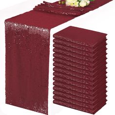 red sequin table runner with white flowers on each side and one long piece of sequined fabric at the end