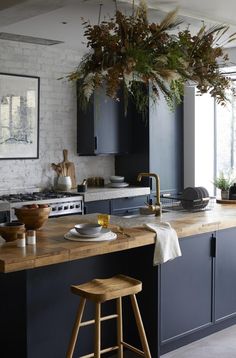 a kitchen with black cabinets and wooden stools in front of an island countertop