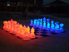 glowing chess set in the dark with blue and red lights on it's sides