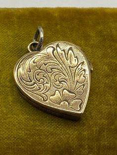 "Antique Victorian hand engraved Heart shaped Locket pendant, ca 1870 Hand engraved heart shaped locket with different floral designs on each side. One side has a shield cartouche that can be monogrammed if desired.  Locket opens and closes properly. The original frames and glassine coverings are secured within. Unmarked. Unsigned. Presumably gold filled.  Measures 1 1/8\" high with bail and 7/8\" wide. Light wear, fitting for age." Vintage Engraved Double Heart Necklace, Vintage Double Heart Engraved Locket Necklace, Heirloom Engraved Locket Necklace For Valentine's Day, Heirloom Engraved Jewelry For Valentine's Day, Valentine's Day Engraved Medallion Jewelry, Victorian Locket Necklace For Valentine's Day, Ornate Engraved Antique Silver Locket Necklace, Victorian Medallion Jewelry For Valentine's Day, Vintage Engraved Locket Necklace For Valentine's Day