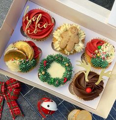 a box filled with cupcakes covered in frosting and decorated like wreaths