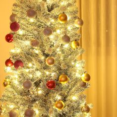 a white christmas tree with gold and red ornaments