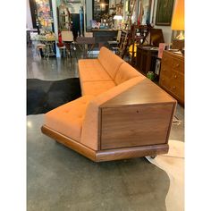 an orange couch sitting on top of a floor next to other furniture in a room