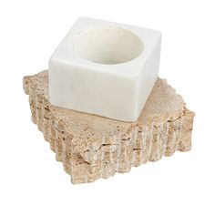 a white square object sitting on top of a rock