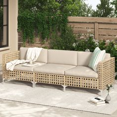 a couch sitting on top of a white rug next to a wooden fence and window