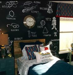 a bedroom with chalkboard walls and bedding in the corner, along with a clock on the wall