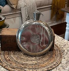 a small round glass bottle sitting on top of a table next to a wooden box