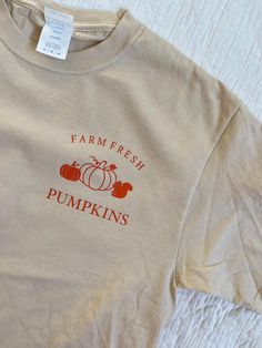 100% Cotton T-Shirt This light beige T-Shirt features an orange pumpkin design. This item is customizable! Make it a custom T-Shirt with personalized shirt colors, design colors, and text. Available upon request, please send me a message if interested. Note that personalization may affect cost of product and shipping timeline. Pumpkin Patch Shirts, Fall Pumpkin Patch, Beige T Shirt, Beige T Shirts, Patches Shirt, Fall Theme, Orange Pumpkin, Pumpkin Design, Pumpkin Orange