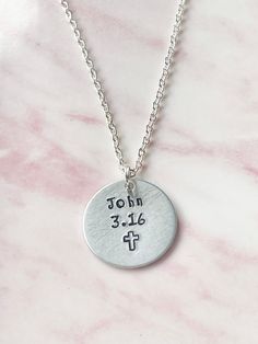 "FEATURES: * The necklace is available with either a silver plated or a sterling silver chain and in various lengths. You can make your selection from the drop down menu. * The aluminium disc measures 25mms (1 inch) in diameter and is hand stamped with John 3.16 and a cross symbol. * John 3.16 - \"For God so loved the world, that he gave his only begotten Son, that whosoever believeth in him should not perish, but have everlasting life.\" * Comes packaged on card inside a clear cello sleeve in a Western Jewelry Necklace, Bible Verse Necklace, Cross Symbol, God So Loved The World, Sabyasachi Jewellery, Bible Verse Gifts, Faith Necklace, Necklace Set Indian, Christian Necklace