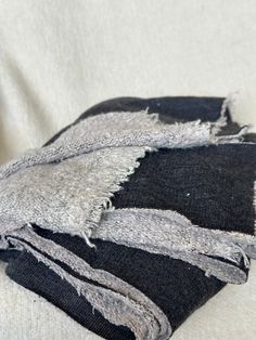 two pieces of black and grey fabric folded on top of each other