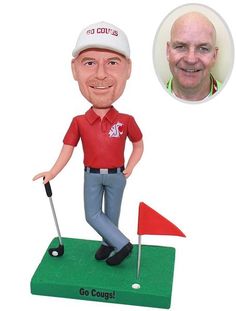 a bobble head golf player with a red shirt and white cap on top of a green course