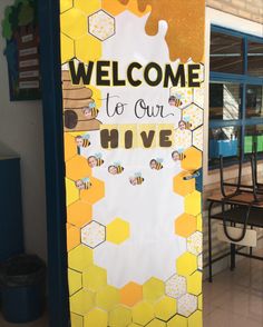 a welcome to our hive sign with bees and honeycombs in front of a building