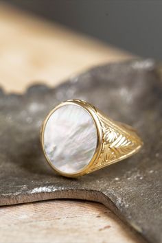 A beautiful signet ring with carvings on the sides made by hand and a mother-of-pearl gemstone in the center. *real images of the ring, taken by us* Mother of Pearl Stone Size: 14x12mm Material: - Sterling Silver 925 - 9K Gold (375) - 14K Gold (585) - 18K Gold (750) *All signet rings are hallmarked on the back for certification* - We offer FREE Worldwide DHL & FedEx Shipping! - Branded DanelianJewelry Gift Box with each order! Carved Mother Of Pearl, Pearl Signet Ring, Ceremonial Engraved Open Signet Ring, Mother Of Pearl Rings, Victorian Oval Signet Ring With Polished Finish, Antique Oval White Gold Signet Ring, Luxury Carved Signet Ring, Luxury Carved Round Signet Ring, White Oval Engraved Hallmarked Ring