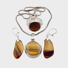 NO. 1693(1) Three vintage pieces of silver jewelry charming Tiger's Eye stone: Necklace: Hallmark: 835 Size: approx. 38 cm - Pendant: approx. 29 x 18 mm (eyelet included) Weight: 11.82 g Earrings: Hallmark: - / at least 800 silver tested Weight: 2.68 g Size: approx. 26 x 11 mm Ring: Hallmark: 835 Size: Ring: Ø approx. 55 (adjustable) - ring top head: approx. 16 x 16 mm Weight: 5.81 g Note: We sell antique/vintage pieces of jewelry, so there might be some signs of wear due to their age. Please lo Fine Jewelry In Polished Metal, Fine Jewelry With Polished Metal Finish, Metal Jewelry With Natural Stones In Round Shape, Round Metal Jewelry With Natural Stones, Vintage Sterling Silver Dangle Jewelry, Silver Jewelry With Natural Stones, Antique Metal Jewelry With Round Pendant, Gold Sterling Silver Jewelry With Cabochon, Silver Jewelry With Natural Round Stones