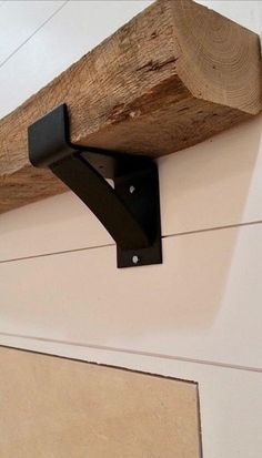 a close up of a piece of wood on the side of a wall with metal brackets